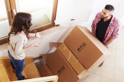 Professional movers handling furniture and packing items during a local house move